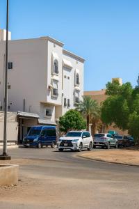un grupo de coches aparcados delante de un edificio en وادي العقيق 201, en Medina 47 fotos más
