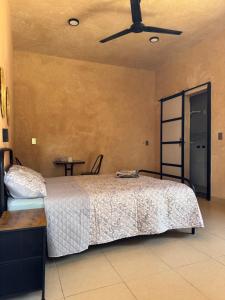 une chambre avec un lit et un ventilateur de plafond dans l'établissement Hospedaje Jardin, à Ocosingo