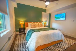 Un dormitorio con una cama y una pared verde. en Historic Kirkwood Location with Arcade & Game room, en Atlanta