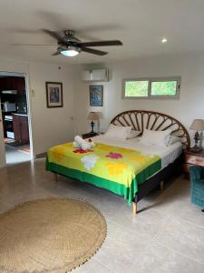 a bedroom with a bed and a ceiling fan at Fare Bungalow in Papeete