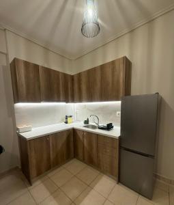 a kitchen with wooden cabinets and a sink and a refrigerator at Domus Philippi in Larisa +19 photos