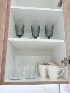 a shelf with glasses and cups on it at Domus Philippi in Larisa