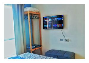 a bedroom with a bed and a tv on the wall at Nuez de la Isla "Azulita Apart" PEATONAL a 6 cuadras! Luminoso y con Balcón al frente Previa seña in Paraná