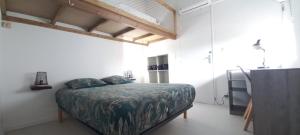 une chambre avec un lit dans une pièce blanche dans l'établissement Villa Pomme cannelle, au Diamant 32 autres photos
