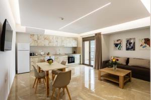カラマタにあるAstir Apartments Kalamataのテーブルと椅子のあるキッチンとリビングルーム