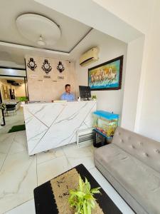 a man standing at a counter in a room at Hotel Devine Zirakpur Chandigarh in Zirakpur