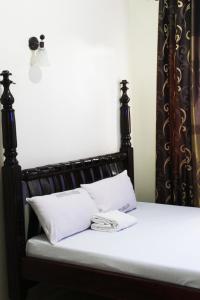 a bed with two white pillows on it at WESTFIELD GARDENS and ACCOMODATION in Namulanda