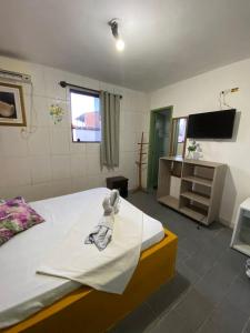a bedroom with a bed with a towel on it at Pousada Porto Seguro in Porto De Galinhas