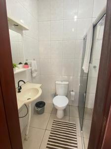 a white bathroom with a toilet and a sink at Cantinho da amizade in Florianópolis