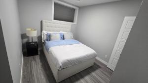 a small bedroom with a bed and a window at Royaldee Cozy Home 2beds & 2baths in Calgary