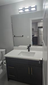 a bathroom with a sink and a mirror at Royaldee Cozy Home 2beds & 2baths in Calgary +29 photos