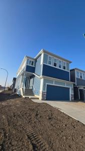 a blue house sitting on top of a pile of dirt at Royaldee Cozy Home 2beds & 2baths in Calgary