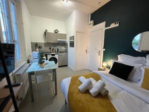 a bedroom with a bed and a table and a kitchen at L'Evraude - Centre-Ville - Gare in Évreux