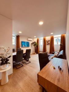 a living room with a table and a dining room at Living Funchal Executive in Funchal