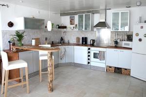 une cuisine avec des armoires blanches et une table à l'intérieur dans l'établissement Ferienwohnung Sorpesee, à Sundern