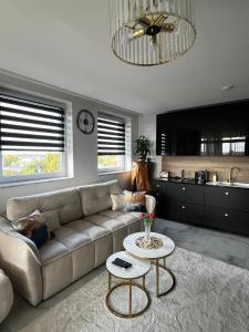 a living room with a couch and a table at Violet Suite in Nyíregyháza
