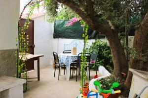 a patio with a table and chairs and a tree at Outra Vida in Mértola