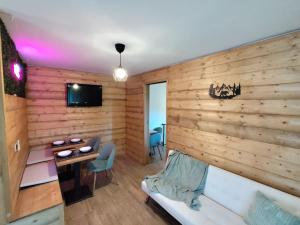 a room with a wooden wall with a bed and a table at MarLee Mountain Home in Pizzone