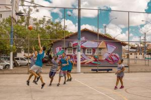 a group of children playing basketball on a court at APTO charmoso com Suíte, Cozinha completa, Wifi, Smart TV, Ar condicionado in Macaé