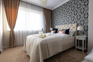 a bedroom with a large white bed with a window at Apartment LUXOR - Airport Katowice-Pyrzowice in Bobrowniki