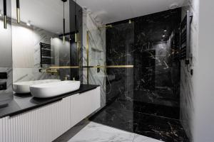 a black and white bathroom with a sink at Apartment LUXOR - Airport Katowice-Pyrzowice in Bobrowniki +31 photos
