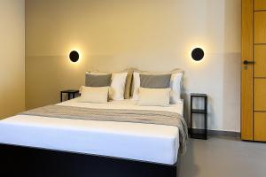 a bedroom with a large bed with white sheets and pillows at APTO charmoso com Suíte, Cozinha completa, Wifi, Smart TV, Ar condicionado in Macaé