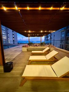 a group of tables on a building with the ocean in the background at Palma-Suite-Santa-Marta in Estación El Salto