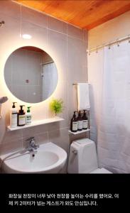 a bathroom with a sink and a toilet and a mirror at 어반 팀버 수원 in Hagwanggyo-dong