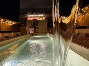 a swimming pool with a water fountain in the middle at BELLADORA Hotel Boutique in Lloret de Mar