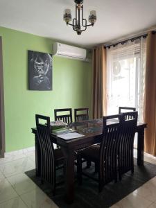 a dining room with a wooden table and chairs at Furnished 2BR Apt with Wi-Fi, AC, gym, pool in Kampala in Kira