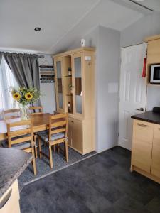 a kitchen and dining room with a table and chairs at Lisa caravan hire 