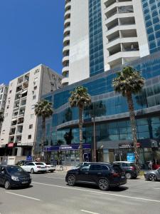 a city street with cars parked in front of a building at Adriatic Suite 101 Taulantia Seafront Stay in Durrës