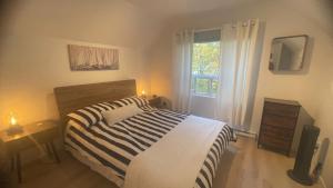 una camera da letto con un letto e una finestra di Maison de vacances à l'Ile d'Orleans a St-Pierre-de-l'Île-d'Orléans