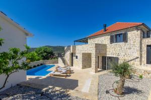 a villa with a swimming pool and a house at Villa Mare Private Stone Villa with Heated Pool and Garden in Vinišće