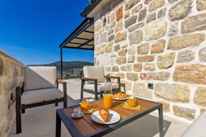 a table with food on it next to a stone wall at Villa Mare Private Stone Villa with Heated Pool and Garden in Vinišće