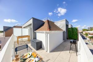 a balcony with a table with food on it at Suite Bauhaus - Proche Paris - Terrasse - Netflix in Bobigny
