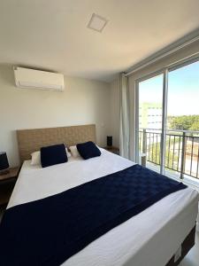 Un dormitorio con una cama grande con una ventana grande. en Home Studio, en Sobral