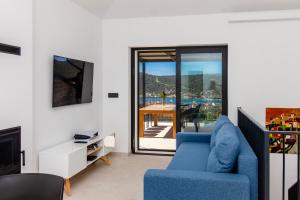 a living room with a blue couch and a tv at Villa Mare Private Stone Villa with Heated Pool and Garden in Vinišće
