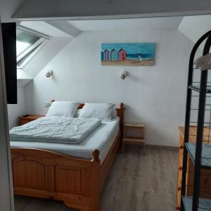 a bedroom with a bed and a painting on the wall at Petite maison de vacances in Cherrueix
