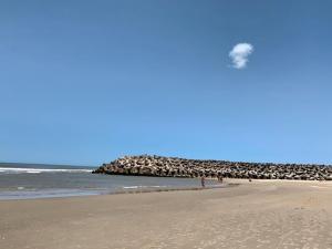 a group of people walking on a beach with a flock of birds at Cabañas Brisa's in Santa Vitória do Palmar