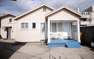 a white house with a porch with a chair on it at Cozy room in East Holywood, 7 min from holllywood, 15 from downtown, 20 to hollywood sing in Los Angeles