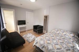 a bedroom with a bed and a chair and a television at Cozy room in East Holywood, 7 min from holllywood, 15 from downtown, 20 to hollywood sing in Los Angeles