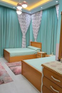 a bedroom with two beds and blue curtains at Hurghada Sky Villa in Hurghada