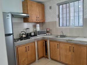 een keuken met houten kasten en een roestvrijstalen koelkast bij Casa para toda la familia o amigos Zona Industrial Monterrey in Monterrey