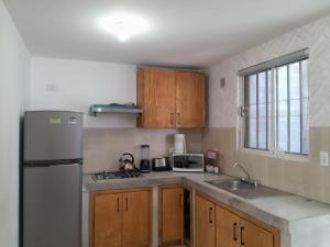 een keuken met een roestvrijstalen koelkast en houten kasten bij Casa para toda la familia o amigos Zona Industrial Monterrey in Monterrey +21 foto's