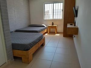 een kamer met twee eenpersoonsbedden en een raam bij Casa para toda la familia o amigos Zona Industrial Monterrey in Monterrey