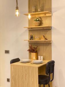 a wooden table with two chairs and plates on it at The Elysium in Karachi