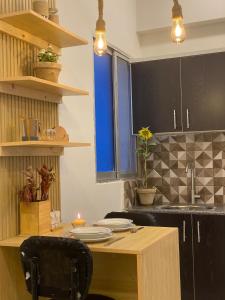 a kitchen with black cabinets and a wooden table at The Elysium in Karachi