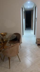 a dining room with a glass table and a chair at Lovely Appart, terrace, opposite the beach in Martil +1 photo