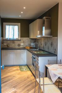 a kitchen with a sink and a table with chairs at I Gelsi di San Bernardino Apartment in Fiorenzuola dʼArda